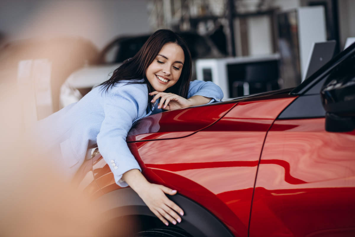 Woman hugging the hood of her new vehicle