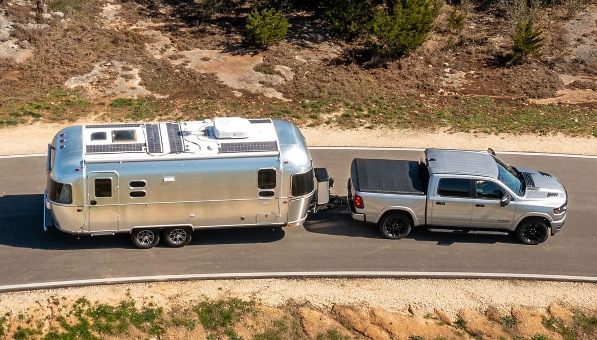 2025 RAM 1500 pulling a camper on a desert road