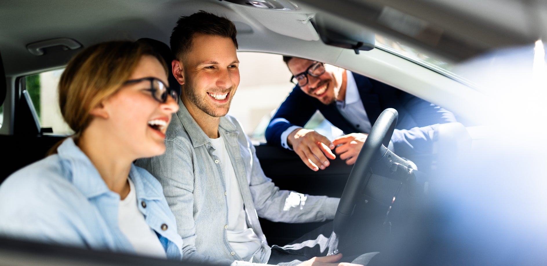 Happy couple exploring a Jeep model with a sales representative